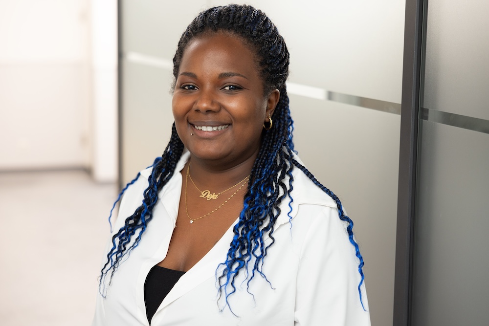 Frau mit Zöpfen lächelt in heller Büroumgebung