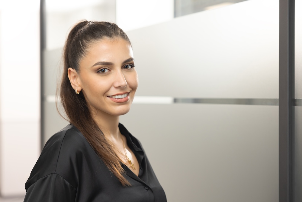 Frau mit strengem Dutt lächelt in die Kamera