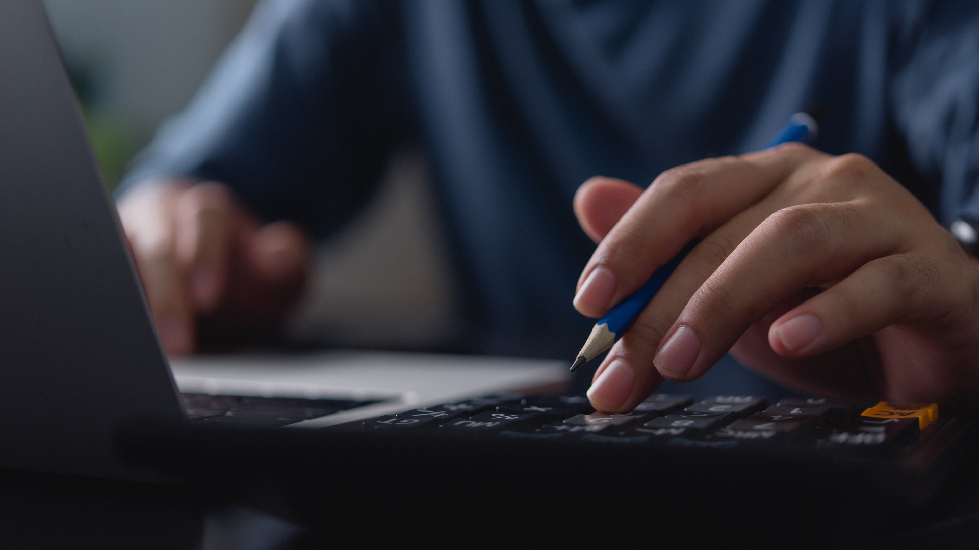 Close-up von Händen bei der Arbeit mit Tablet und Laptop