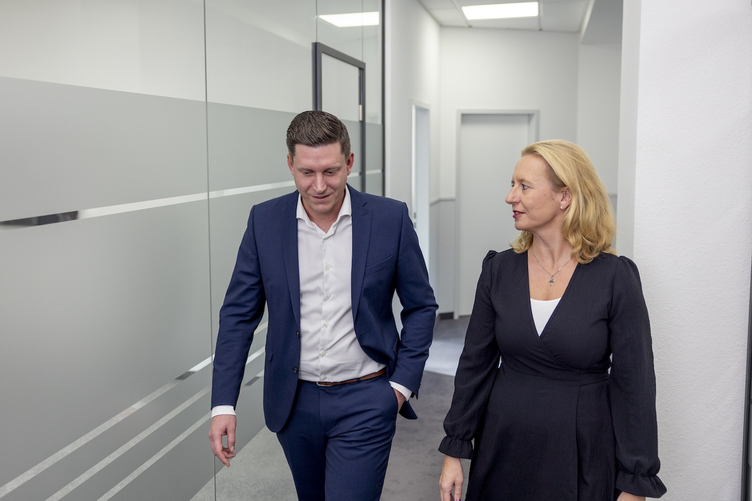 Zwei Personen gehen gemeinsam durch den Büroflur
