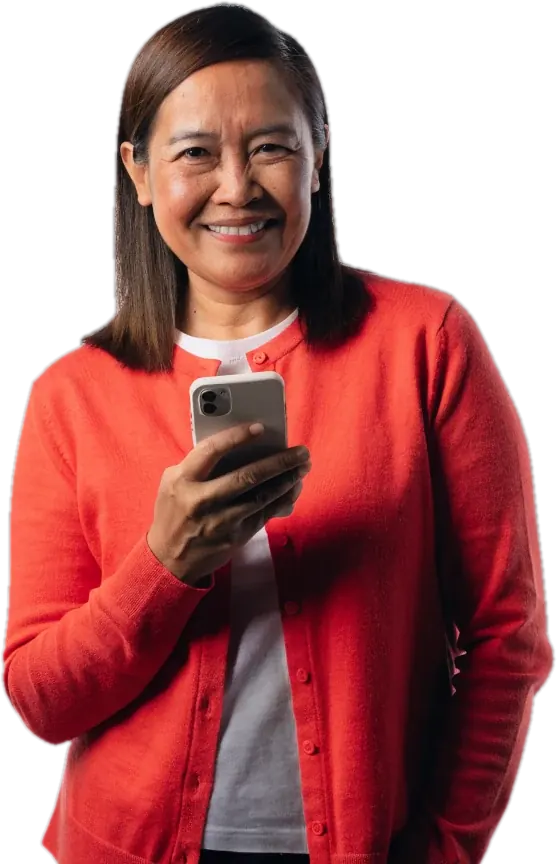 Smiling mother in a coral cardigan holding her phone after being matched with a certified teacher