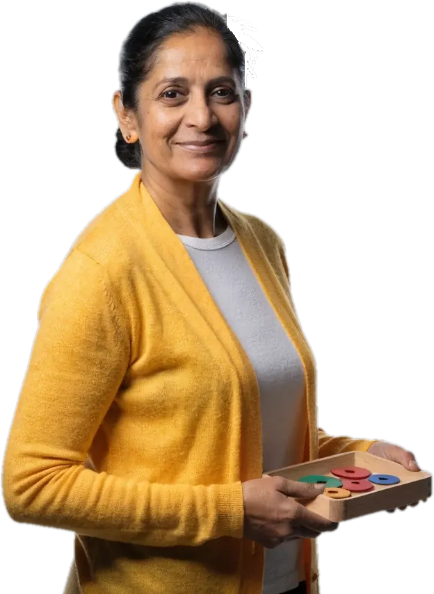 Smiling teacher in a yellow cardigan holding a tray of fraction circles