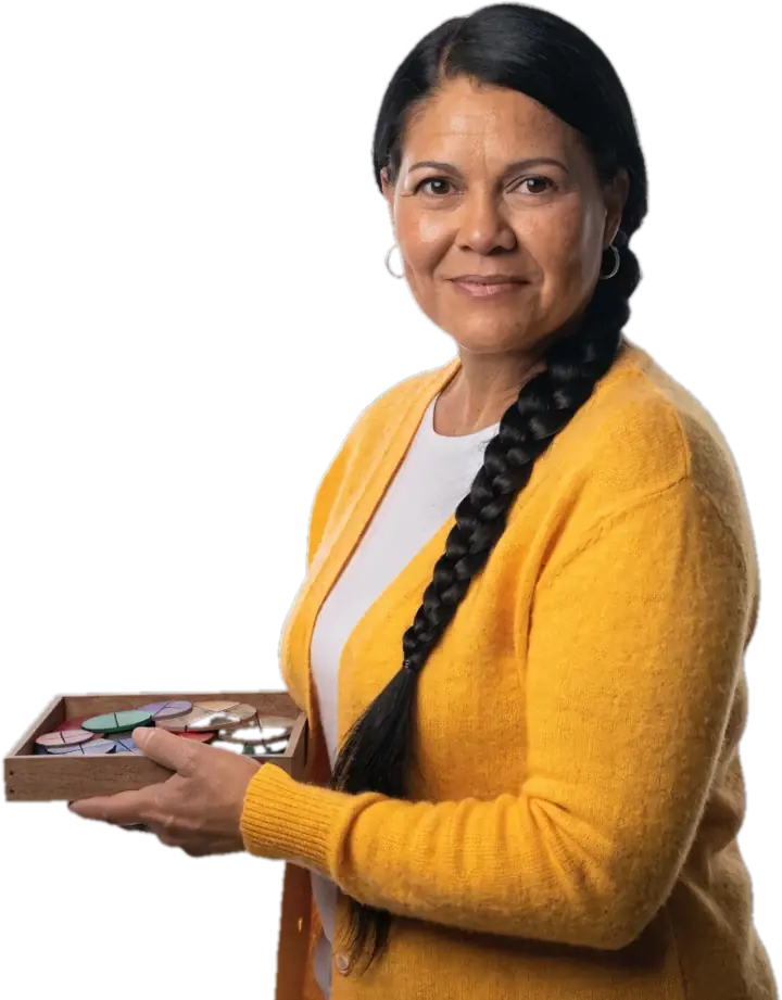 Smiling certified teacher with a long braid holding a tray of fraction circles
