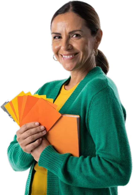 Adult ESL learner in an emerald cardigan holding orange study cards and a notebook