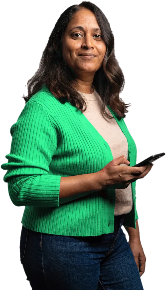Smiling mother in an emerald cardigan checking her phone