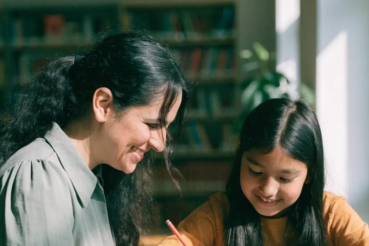 Tutor and student working on a writing lesson at a public library table
