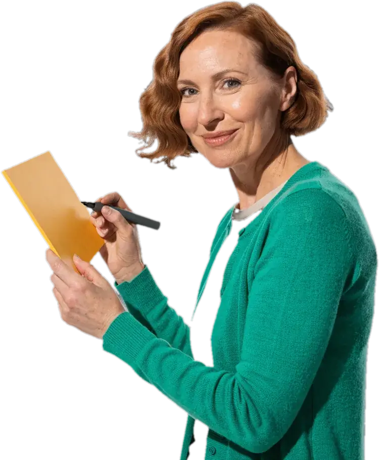 ESL teacher in an emerald cardigan holding a yellow board and a marker