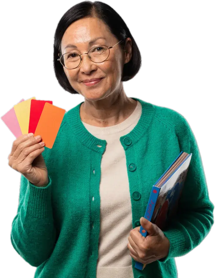 Smiling reading teacher in glasses holding colourful flash cards and a picture book
