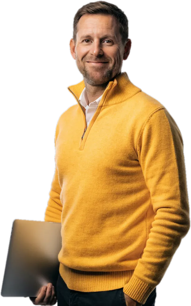 Smiling father in a sunflower-yellow quarter-zip with a laptop under his arm