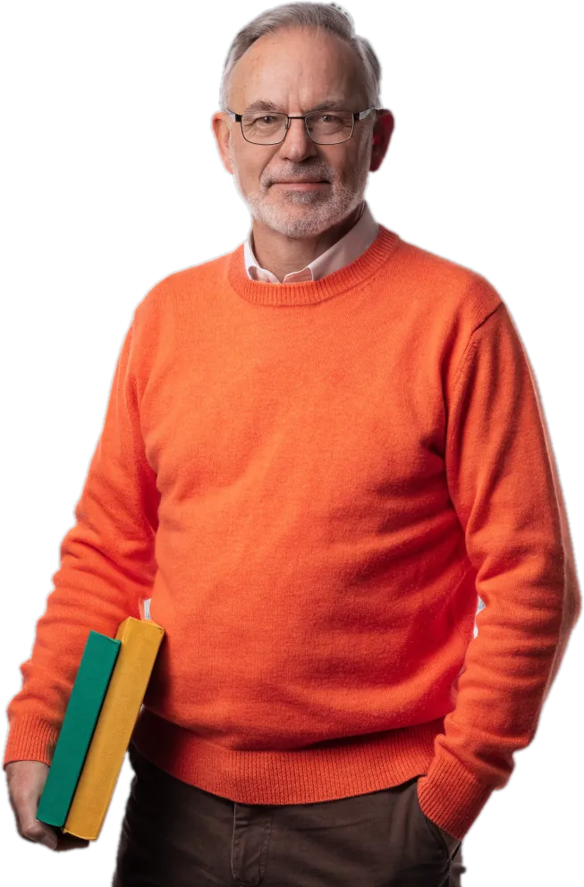 Teacher with a grey beard and glasses in an orange sweater holding two books