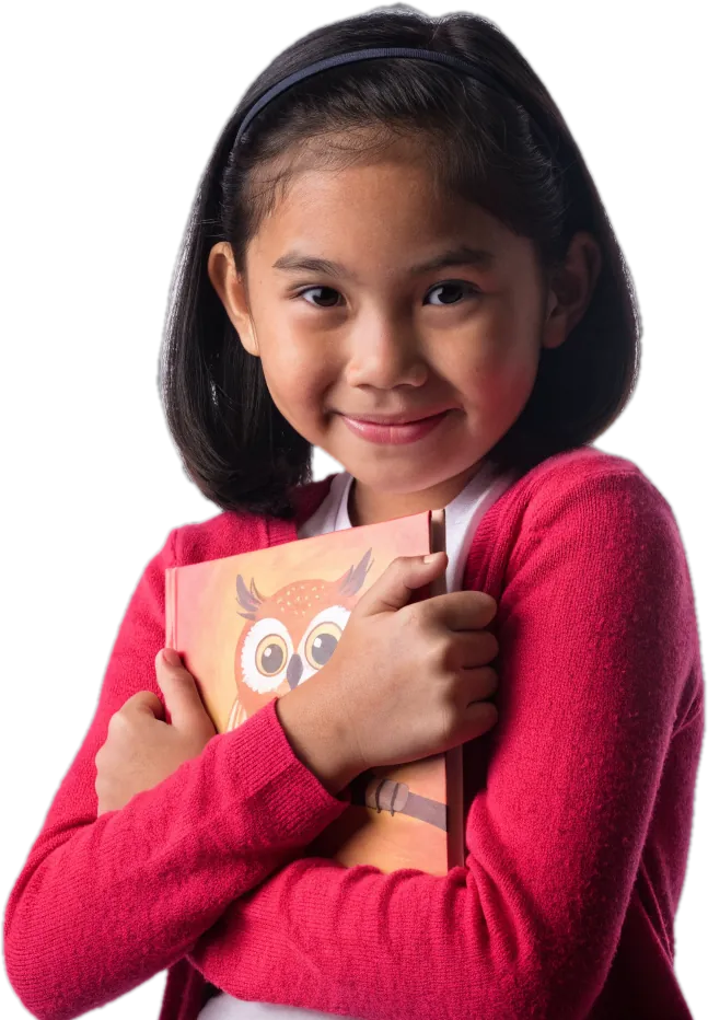 Girl in a pink cardigan hugging a picture book with an owl on the cover