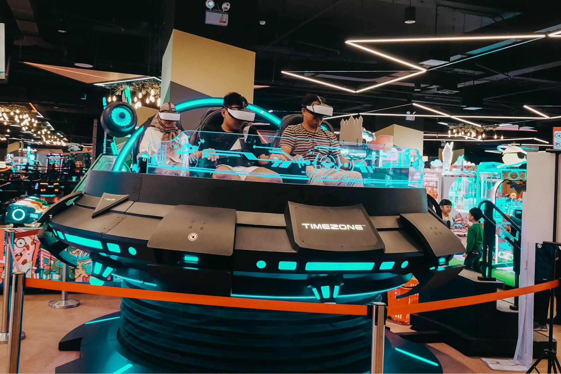 Event attendees wearing VR headsets sit in a circular gaming module at a tech conference. 
