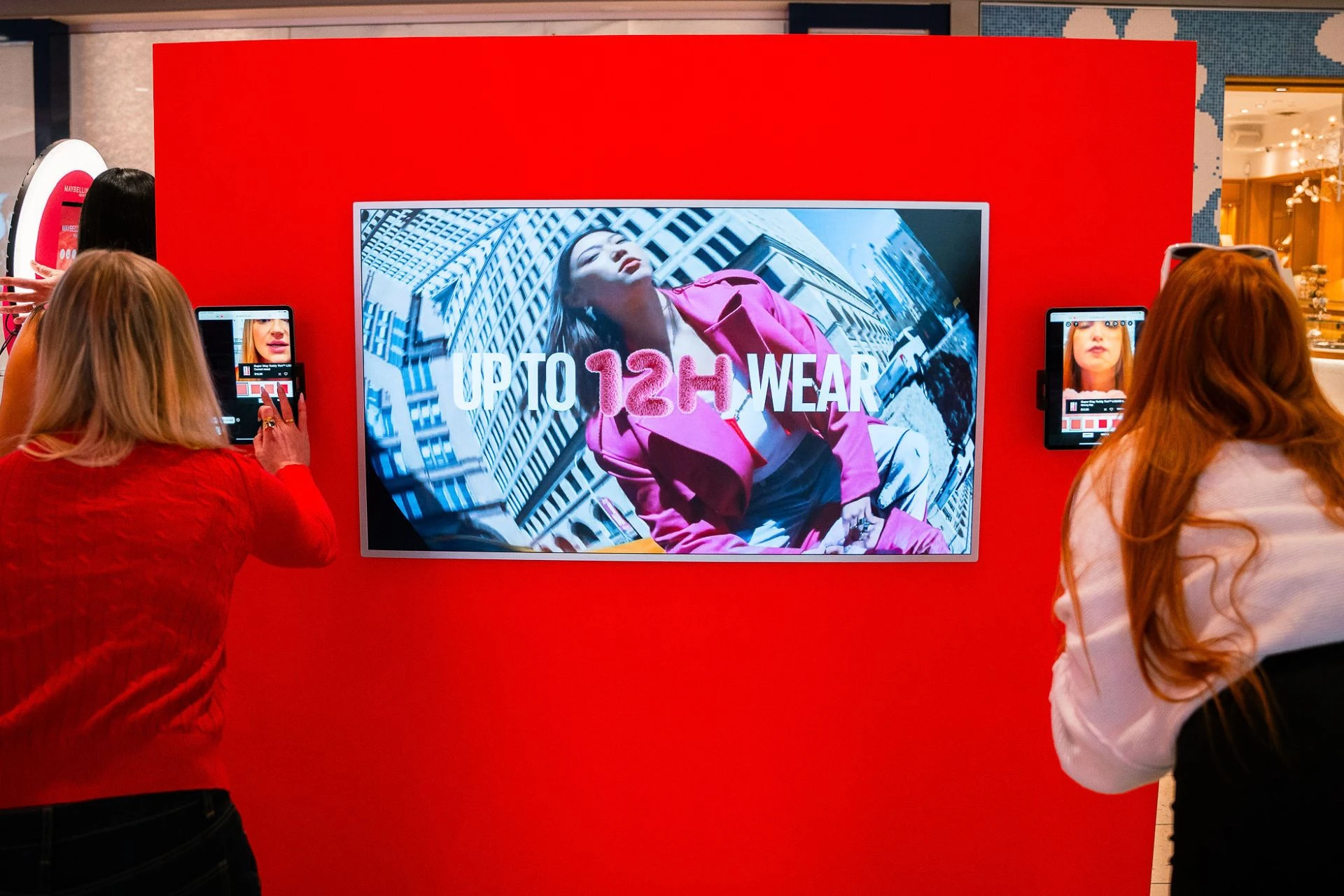Women trying out lipstick at a booth