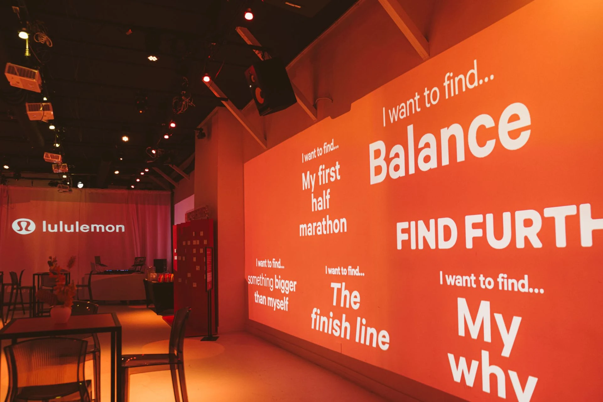 An event with orange lighting sponsored by Lululemon