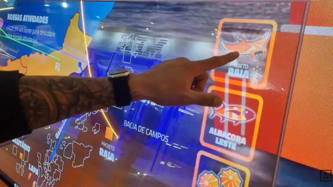 Visitante tocando o menu na tela transparente da Repsol