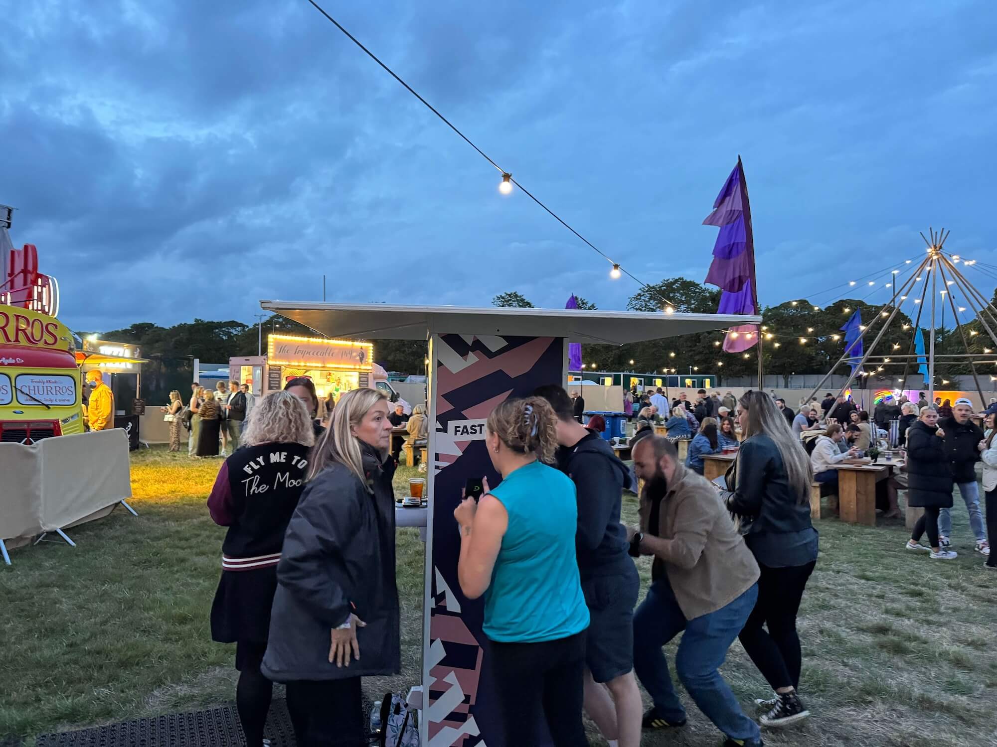 Festival attendees gathered around a Crable phone charging totem, using fast charging stations to stay connected during a busy live event.