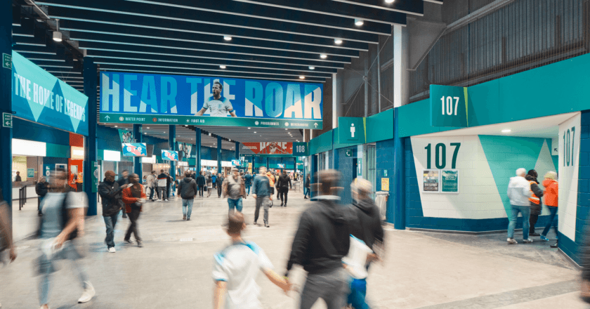 People moving through a stadium concourse, illustrating how experience is shaped by environment and flow