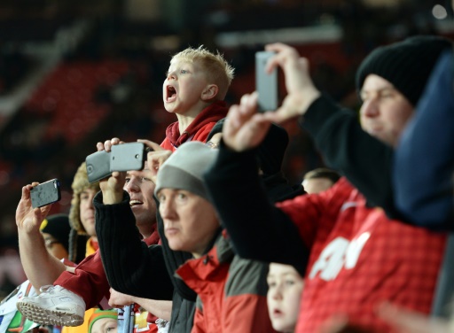 Large stadium crowd with people using mobile phones during live event