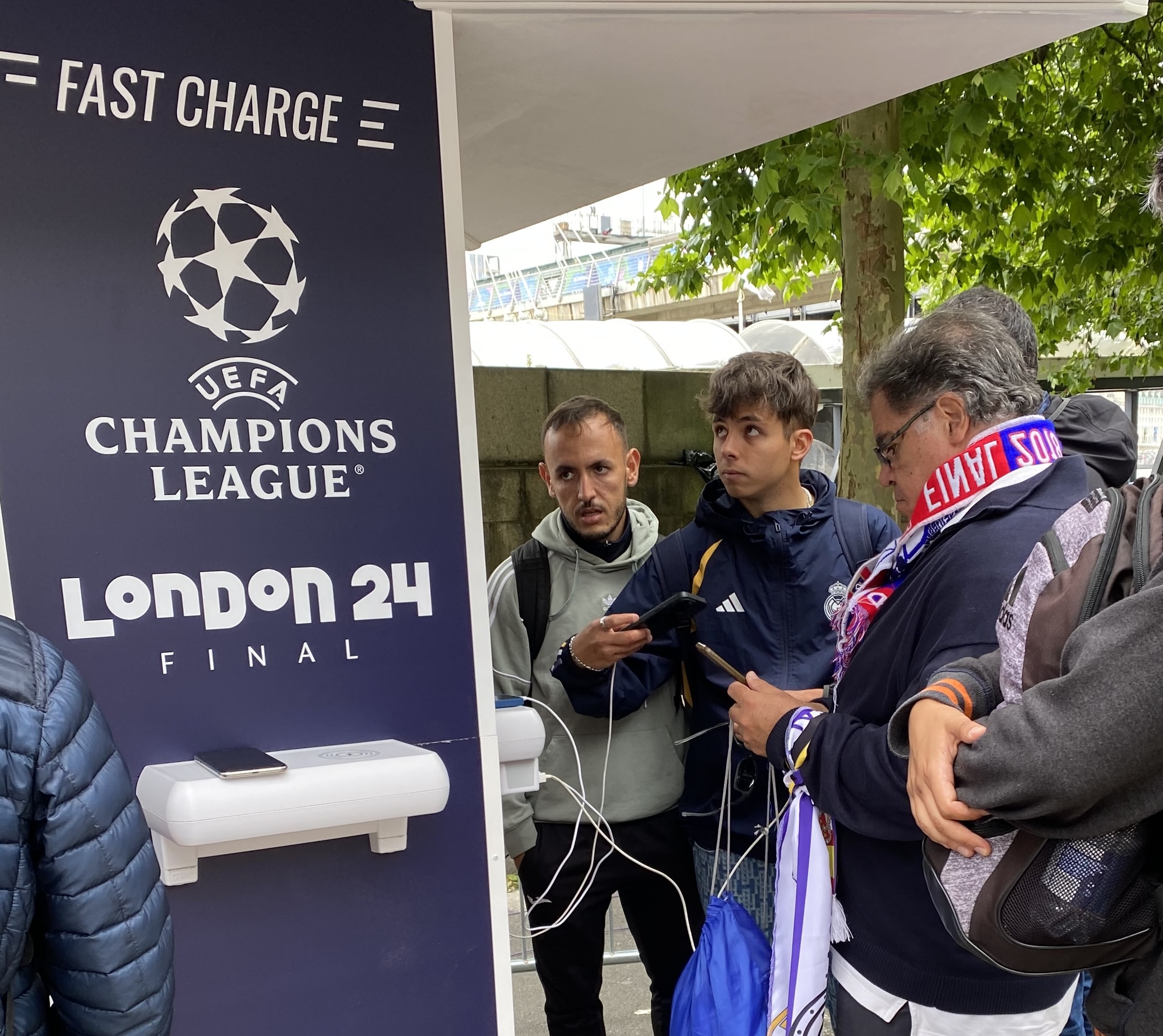 Football fans charging their phones at a Crable Charging Station during the UEFA Champions League Final in London.