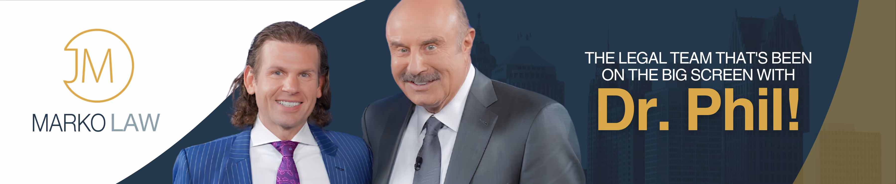 Two men in suits, one with long hair and purple tie, the other bald with a gray tie, smiling.