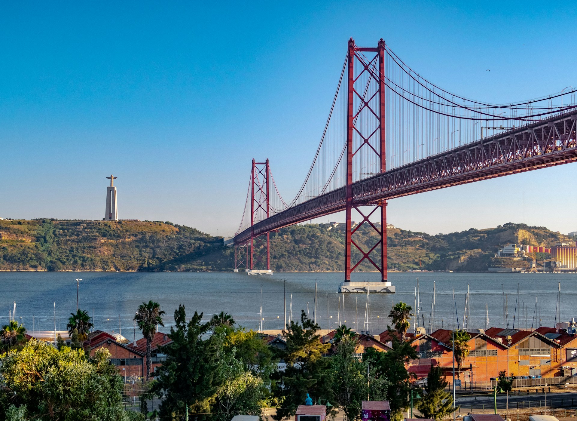 Die Ponte 25 de Abril über dem Tejo in Lissabon, im Hintergrund die Cristo-Rei-Statue