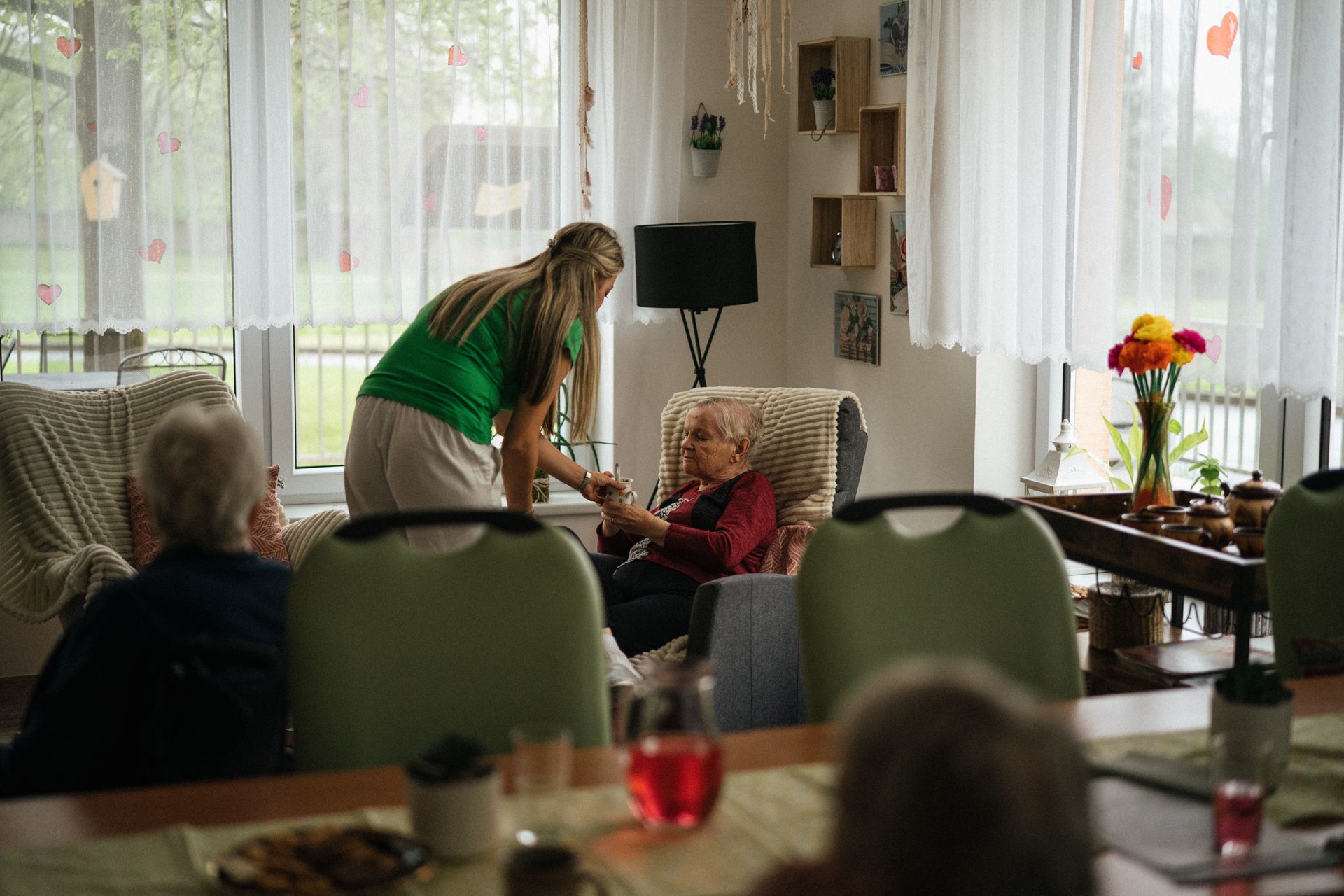 Caregiver supporting an elderly resident in a UK care home setting