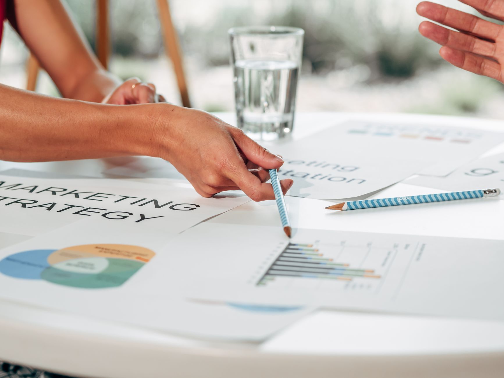 Marketing director and team reviewing budget charts and campaign data in a UK office meeting