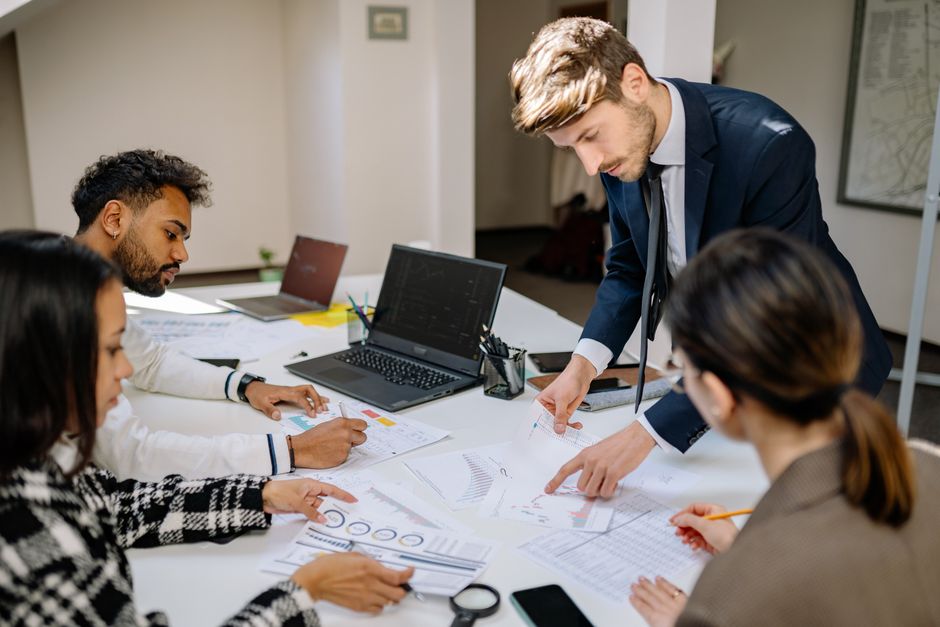 Finance team reviewing financial reports during a leadership handover meeting in a UK office