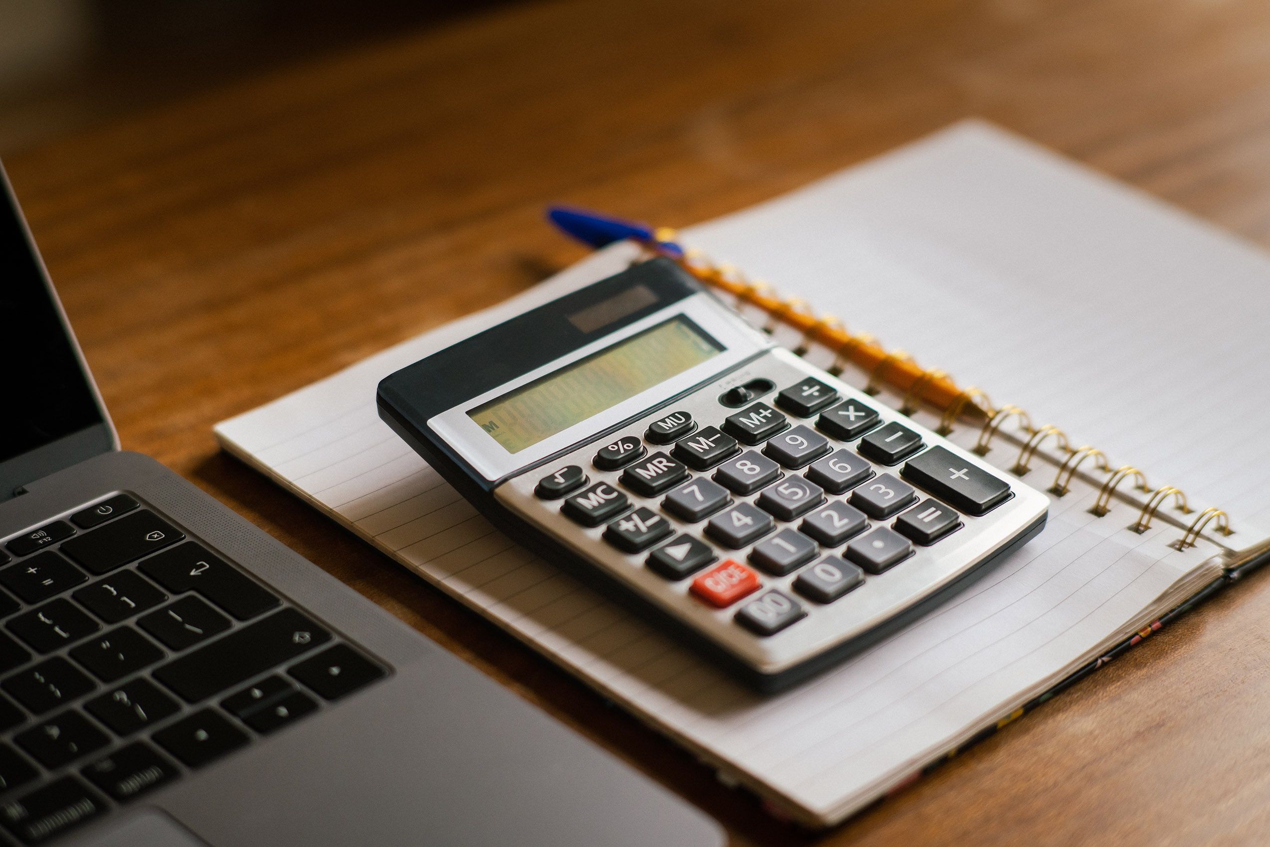 Calculator, glasses and paperwork on a desk, representing the accounts a newly incorporated UK business must manage