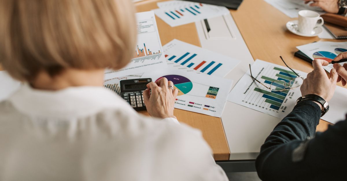 Finance managers reviewing financial documents and calculating figures during a detailed payment review