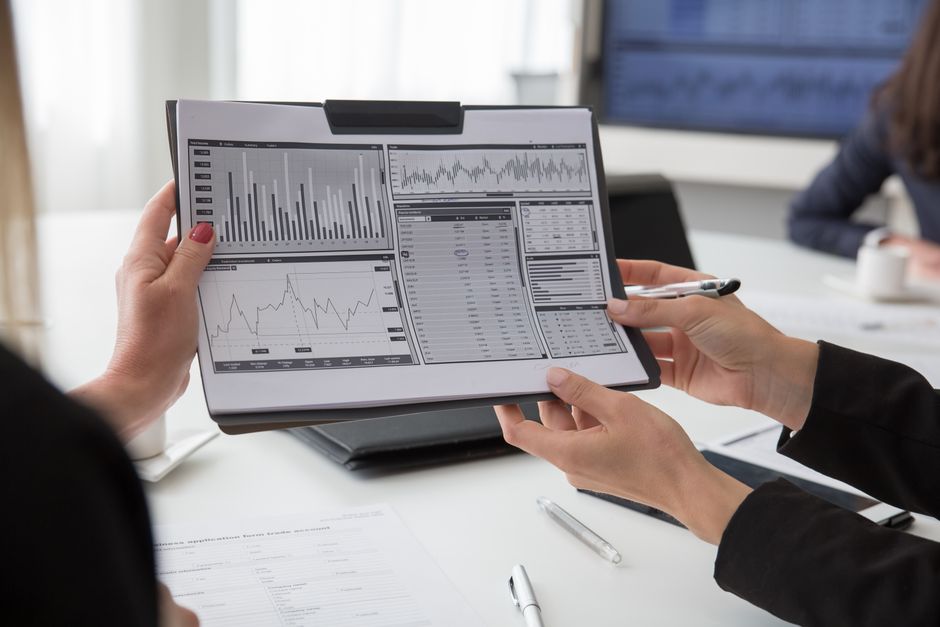 Finance professionals reviewing data charts on paper during a business meeting