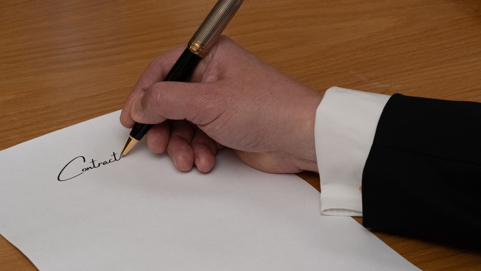 Fountain pen resting on a business contract, picturing the cost of a bad finance hire