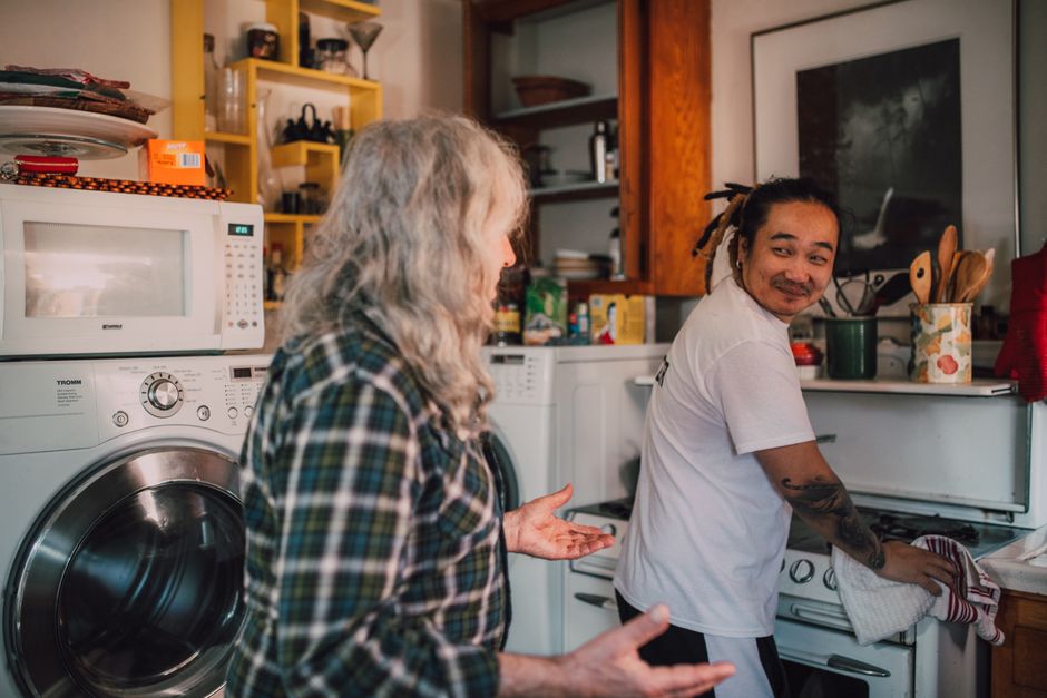 A support worker chatting with an older person in their kitchen at home, the kind of daily visit that home care funding rates have to cover