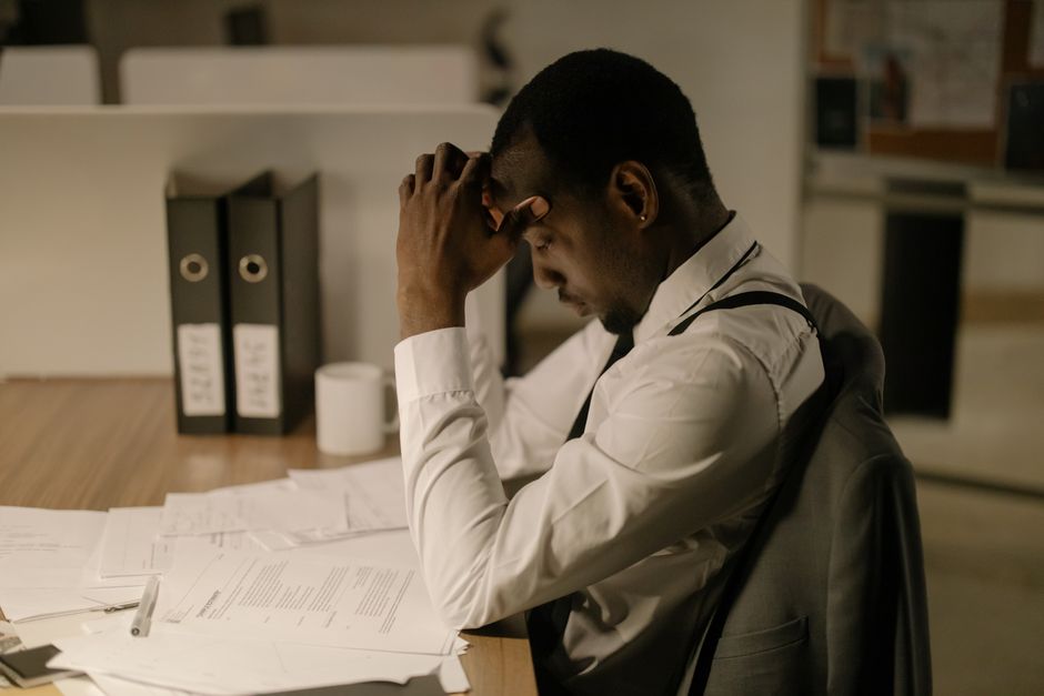 Stressed Detroit employee reviewing legal documents and employment contracts Stressed Detroit employee reviewing legal documents and employment contracts