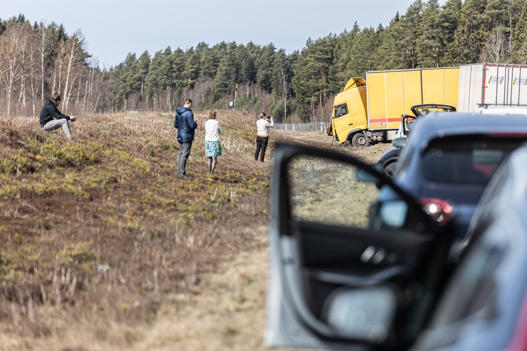 Commercial truck accident scene with investigators analyzing highway debris