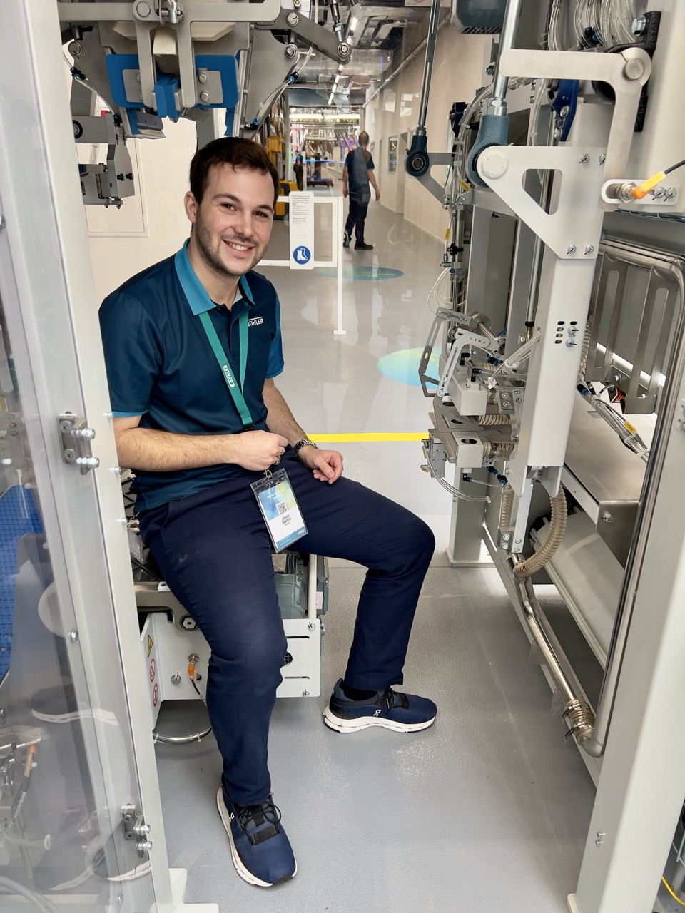 Junger Techniker zeigt eine Maschine zum Verpacken