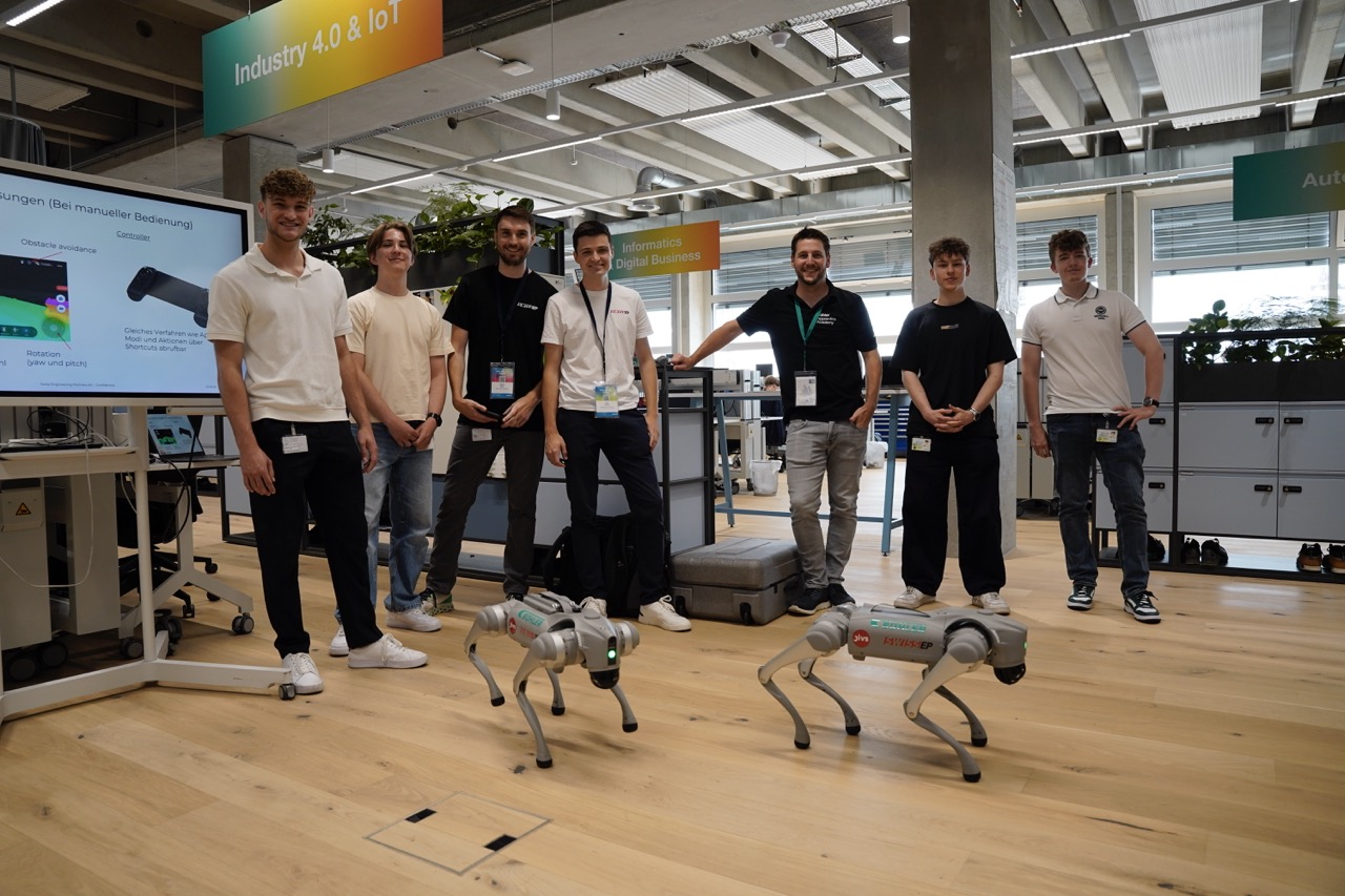 Mehrere Auszubildende mit zwei Roboterhunden