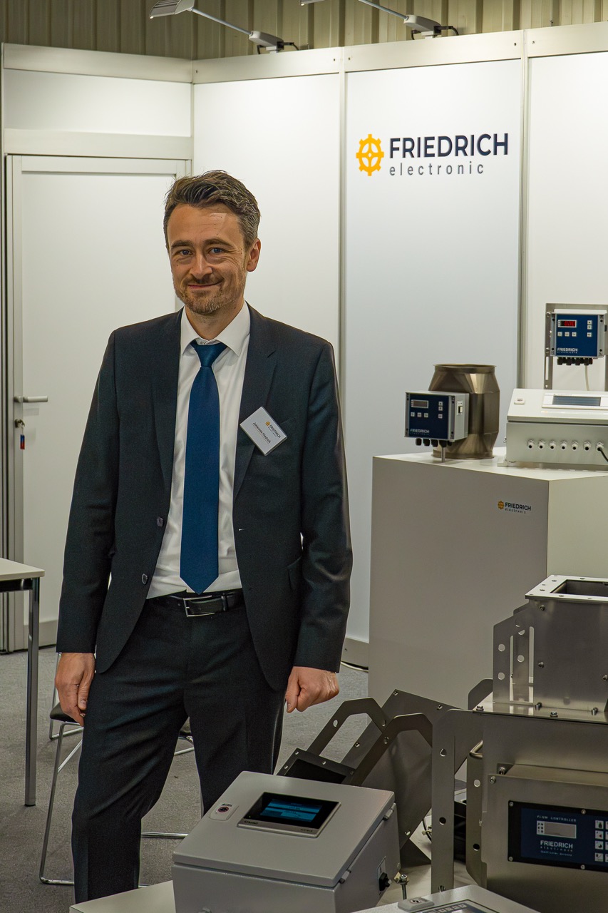 Ein Mann vor seinem Messestand