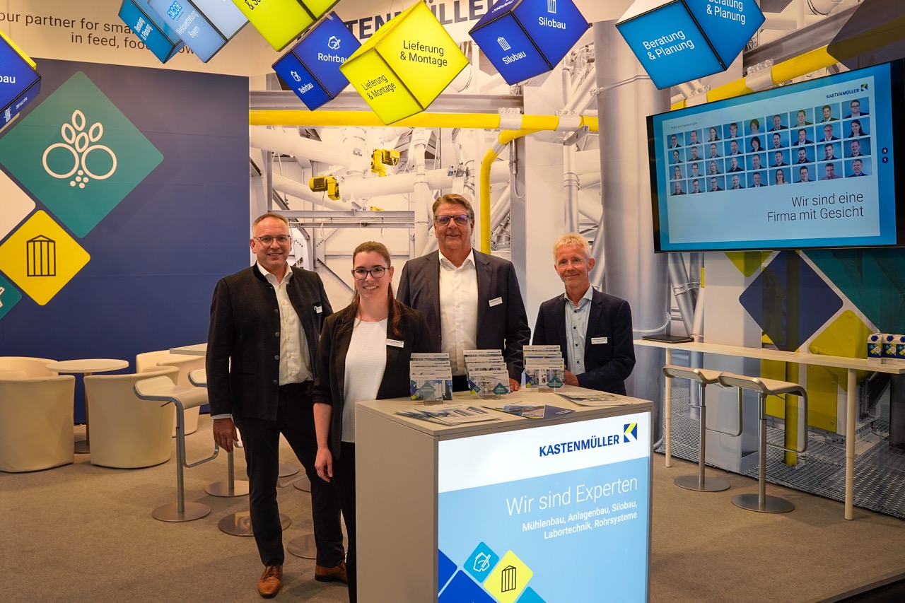 Ein Team aus vier Leuten vor dem Messestand.