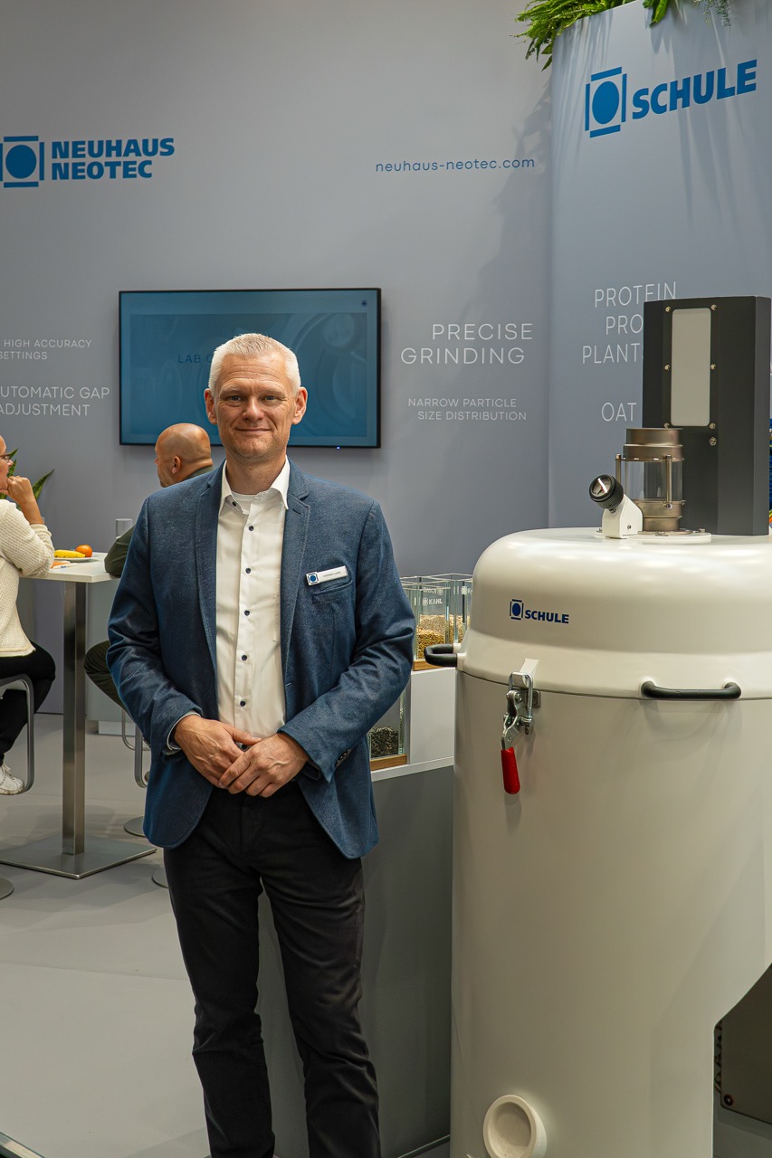 Ein Mann vor seinem Messestand und seinem Schäler