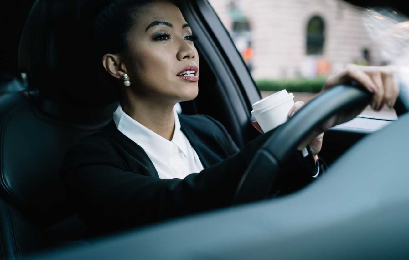 business woman drinking coffee while driving
