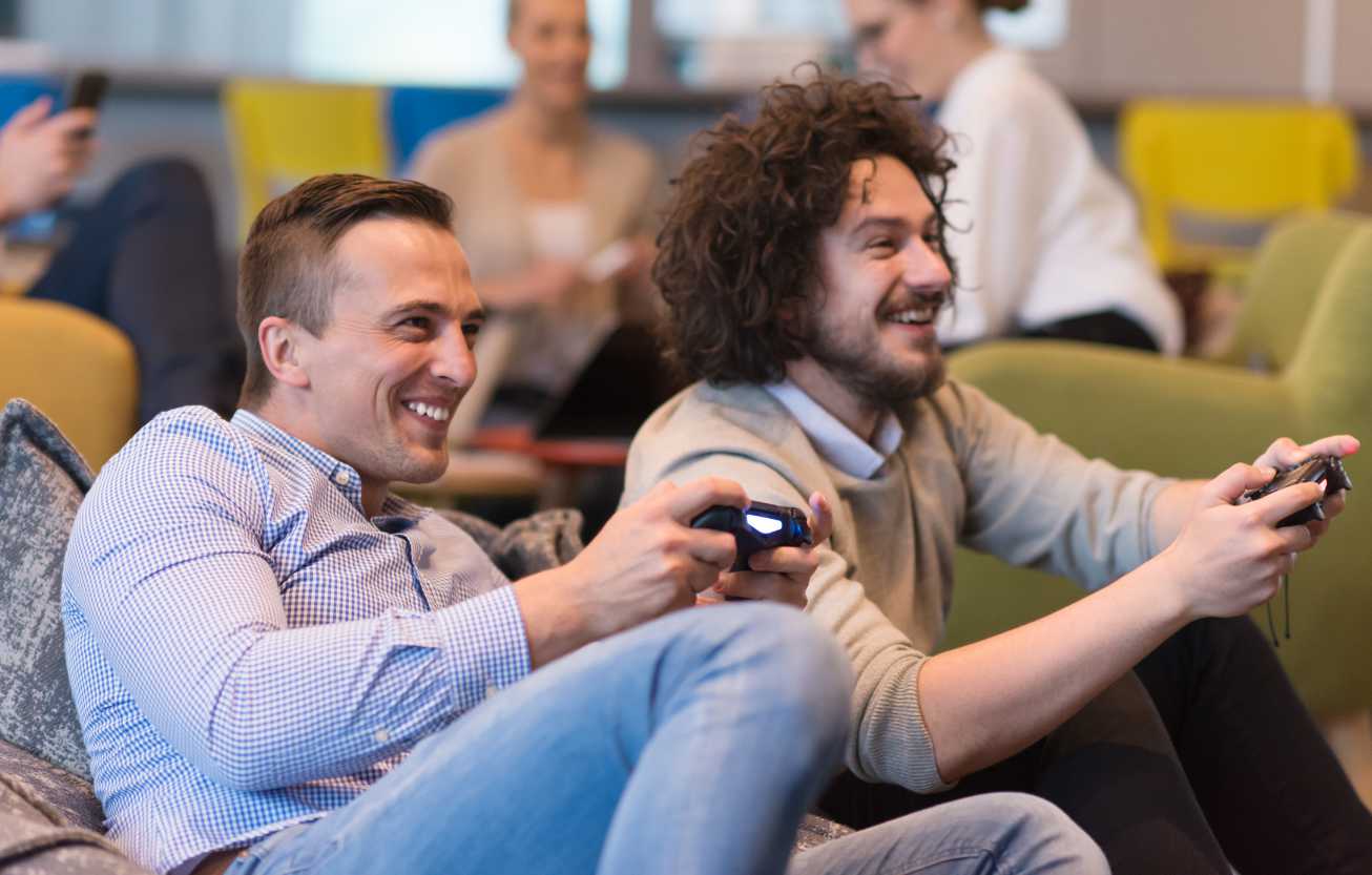 two men sitting down enjoying a video game