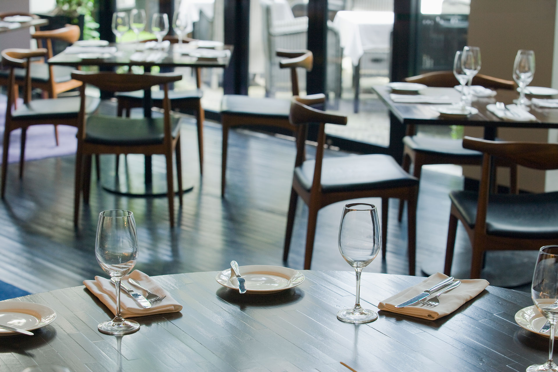 A modern restaurant interior showcases durable laminate flooring in a wood finish. The flooring offers a practical, easy-to-clean surface ideal for high-traffic dining spaces.