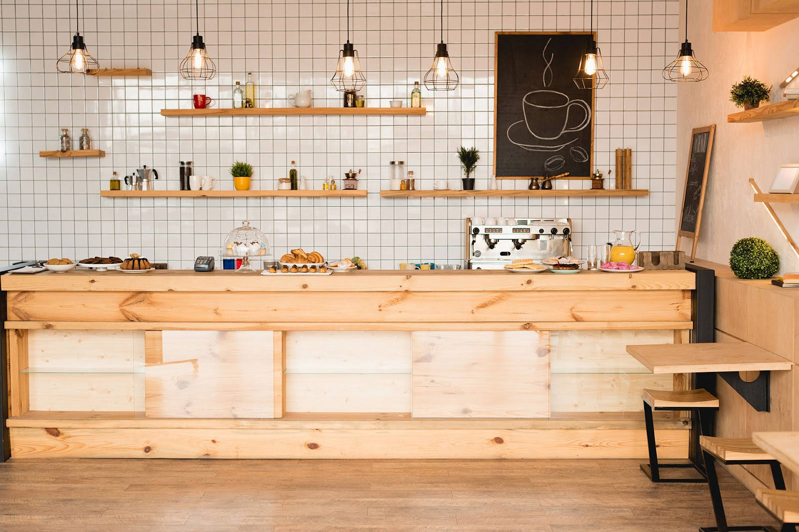 Modern cafe with tiled wall, timber shelves and cabinetry.