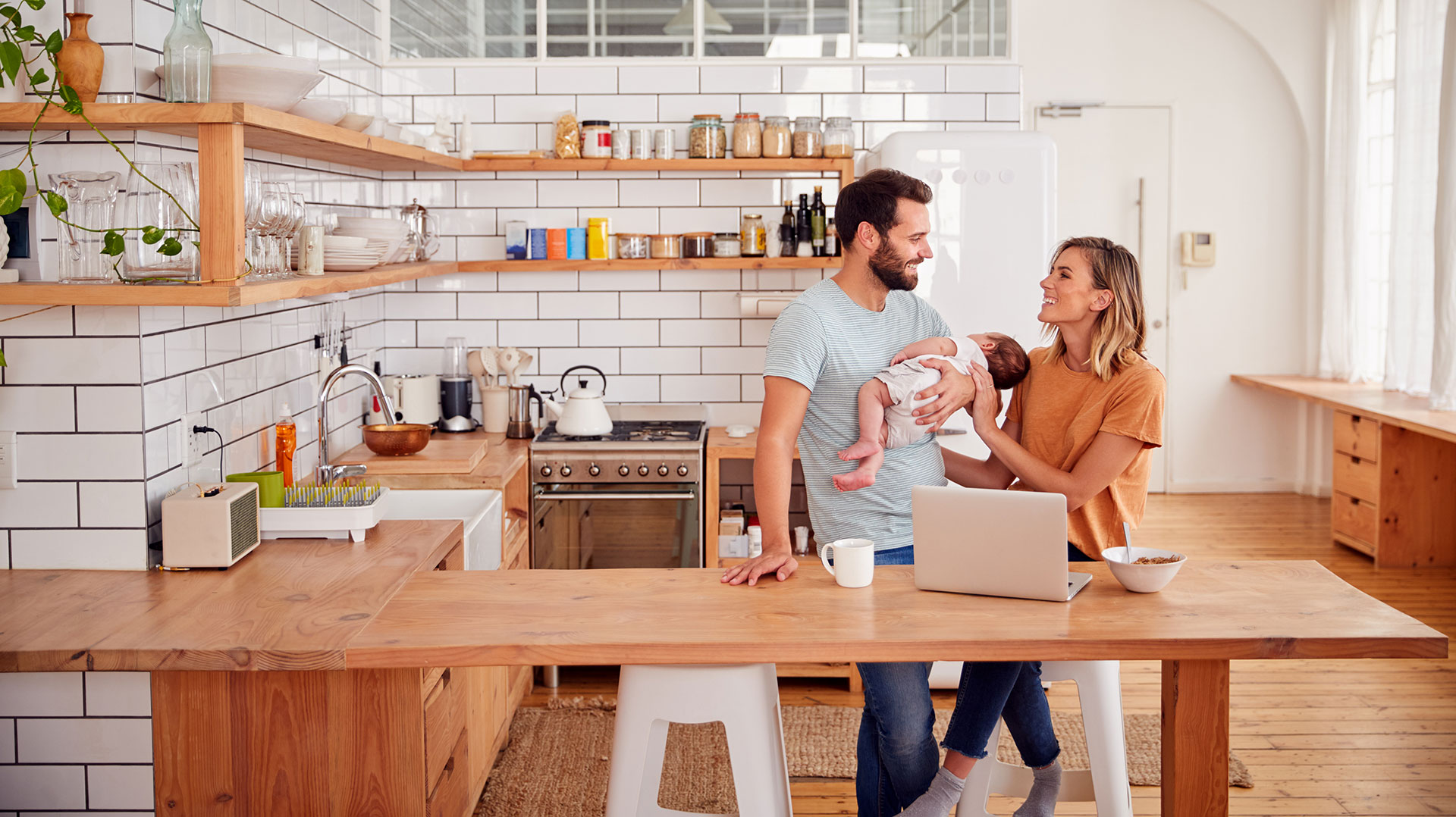 Family time in a cozy wooden kitchen with warm-toned hardwood flooring. The natural wood textures create a welcoming atmosphere for shared meals and conversation.