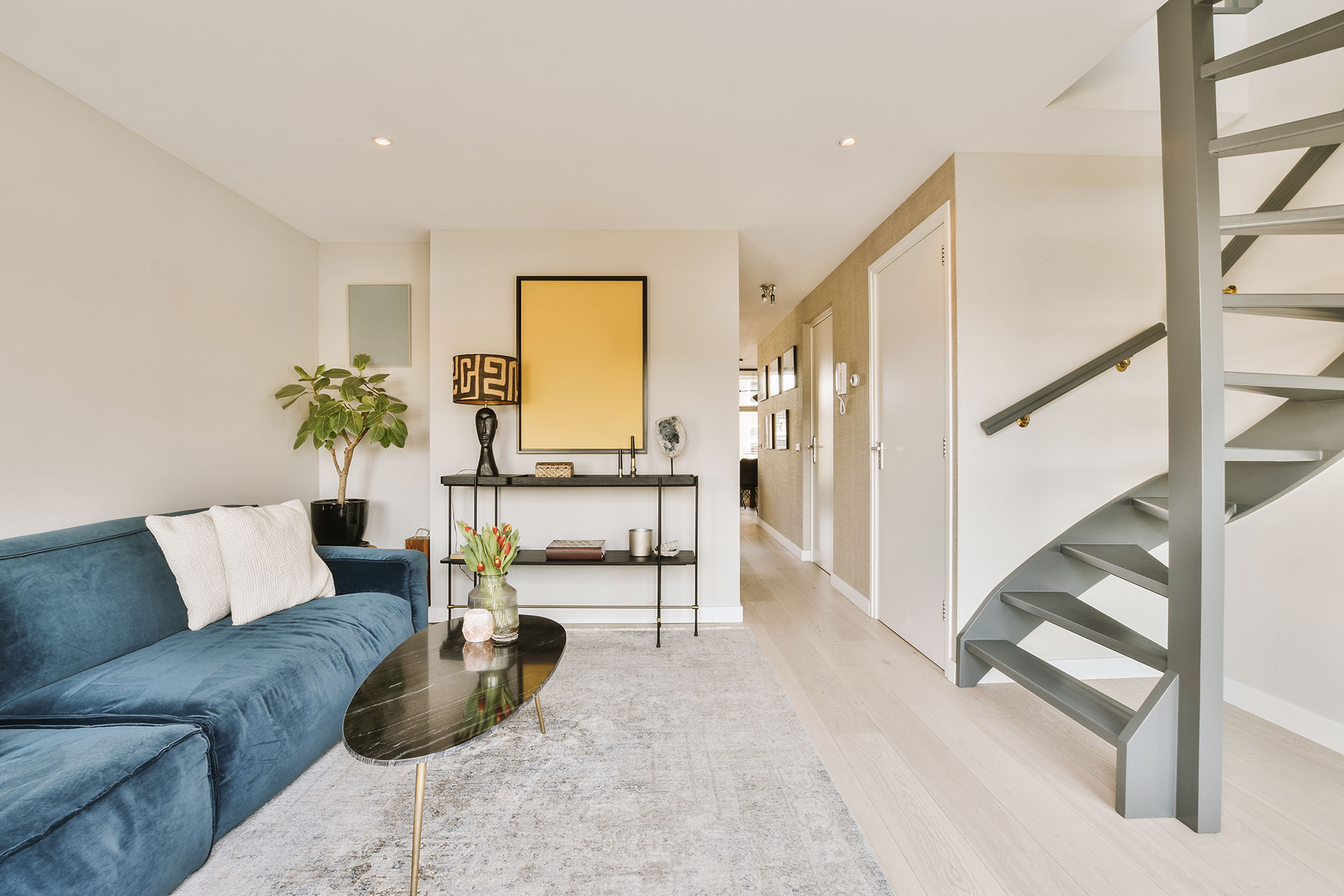 Light laminate flooring in a small room reflects natural light and creates an open, airy feel. The pale wood tones visually expand the compact space and complement the minimalist interior.