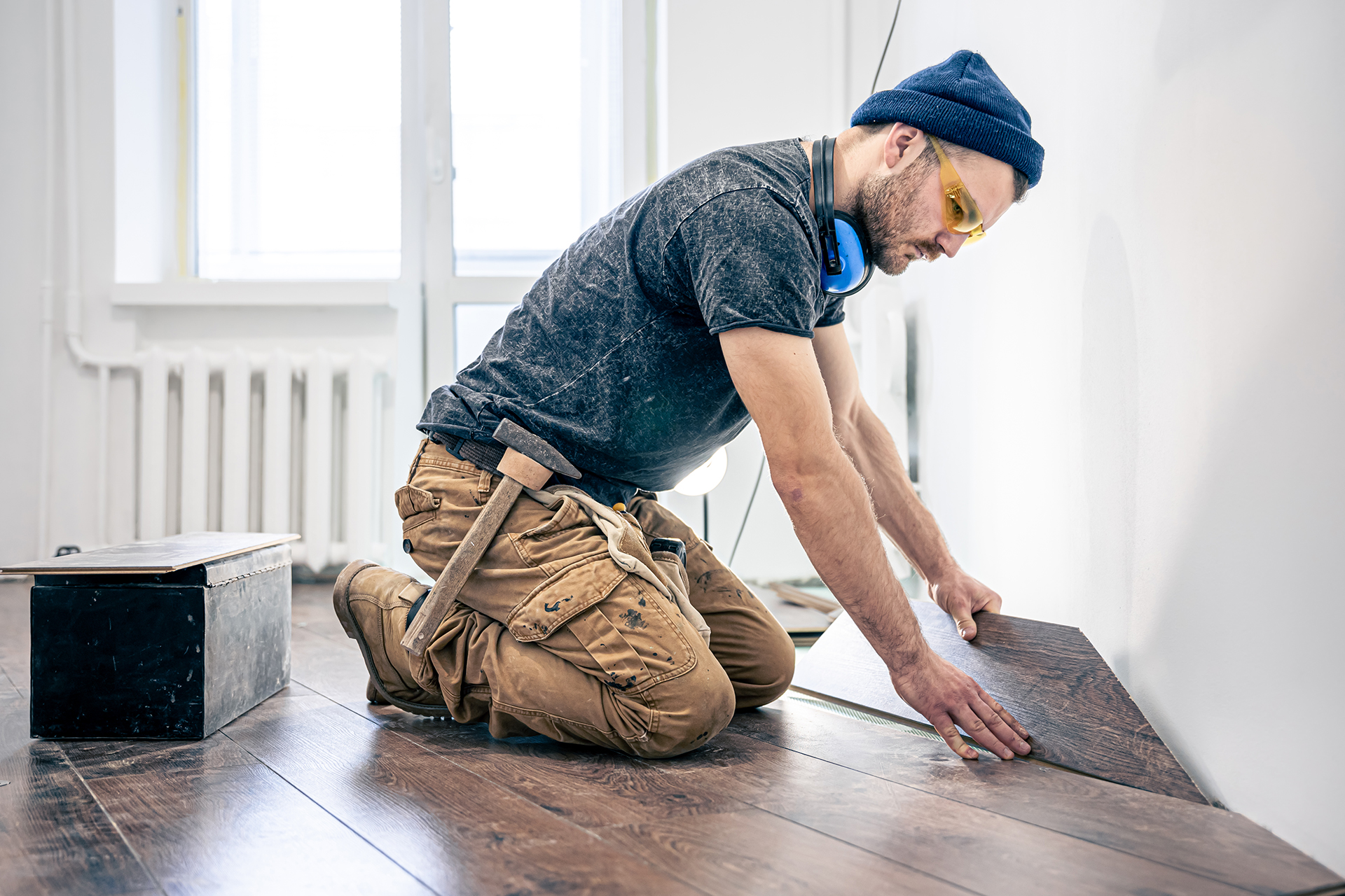 A man installs durable and affordable laminate flooring that adds a premium look to the interior. Combines practicality with stylish, wood-like design.