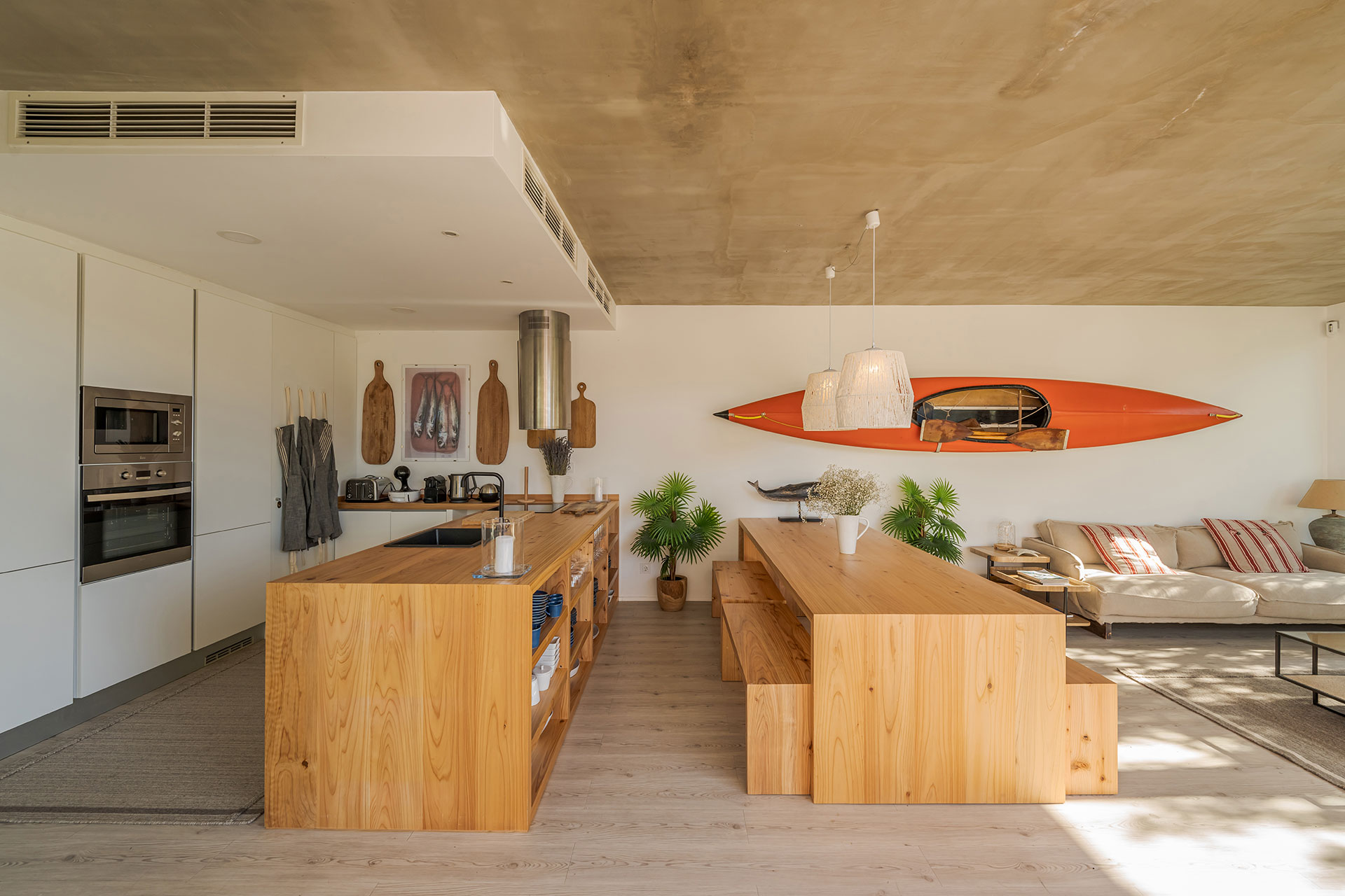 Open plan living room and kitchen in an Australian home with vinyl plank flooring in a light wood tone.