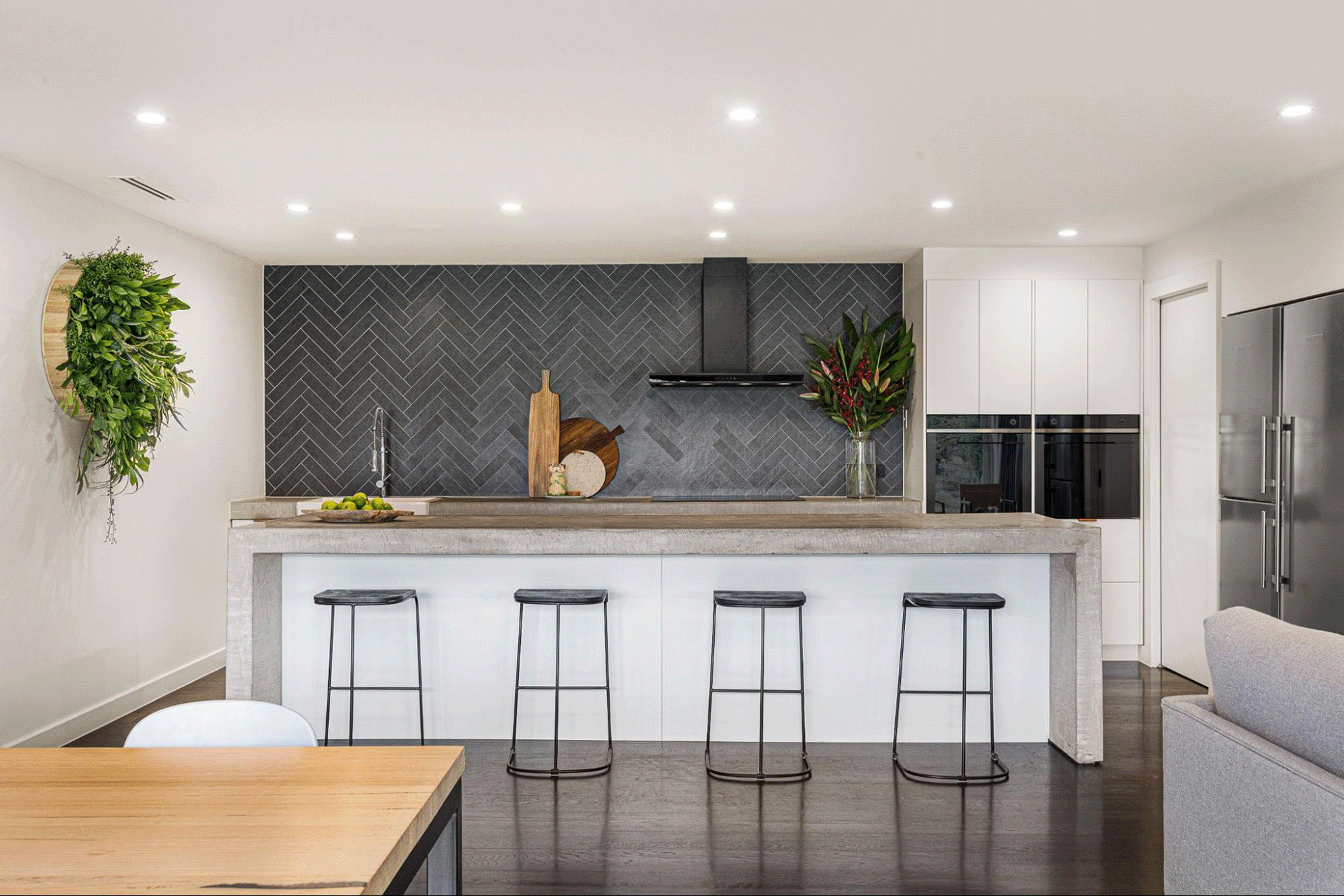 Contemporary kitchen distinguished from the open-plan living space by contrasting flooring materials
