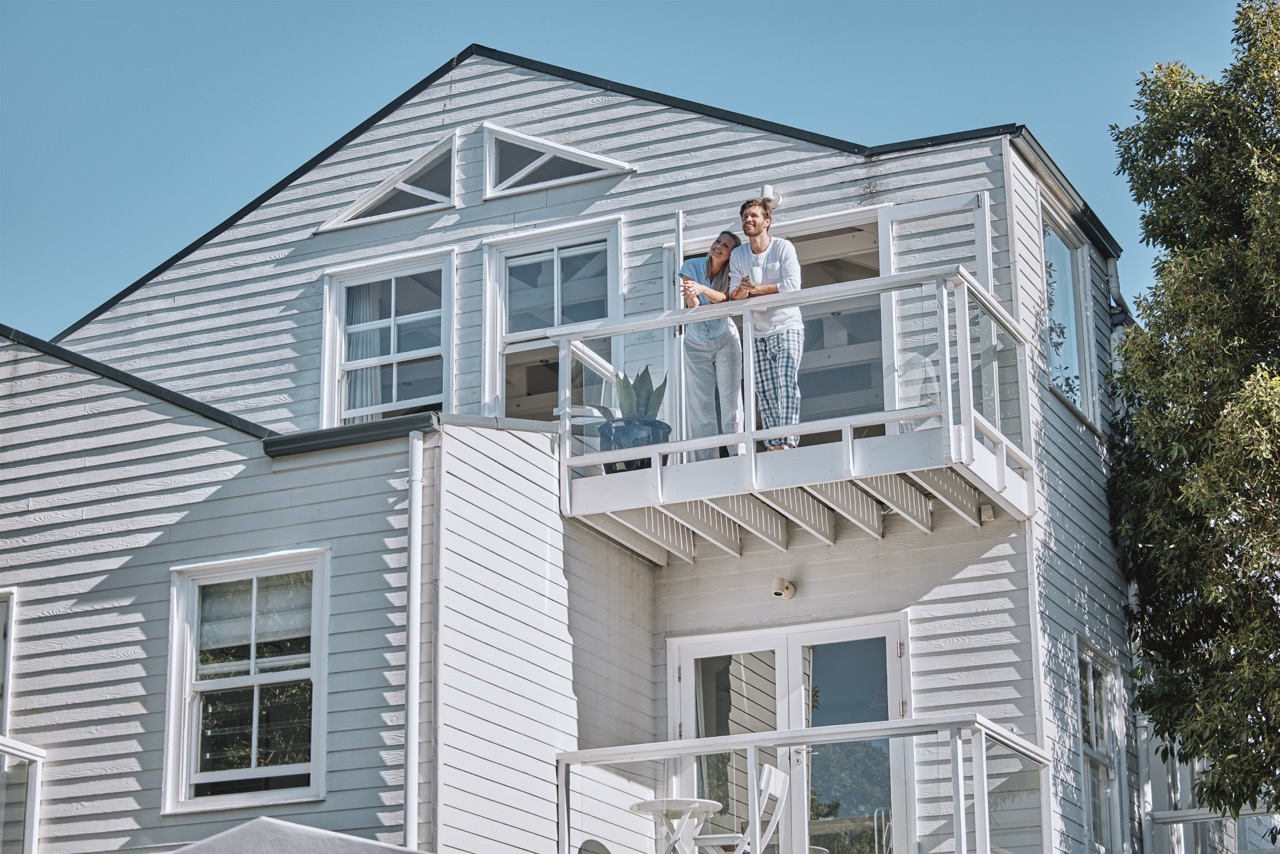 Couple standing on the balcony of a beautiful Illawarra coastal home